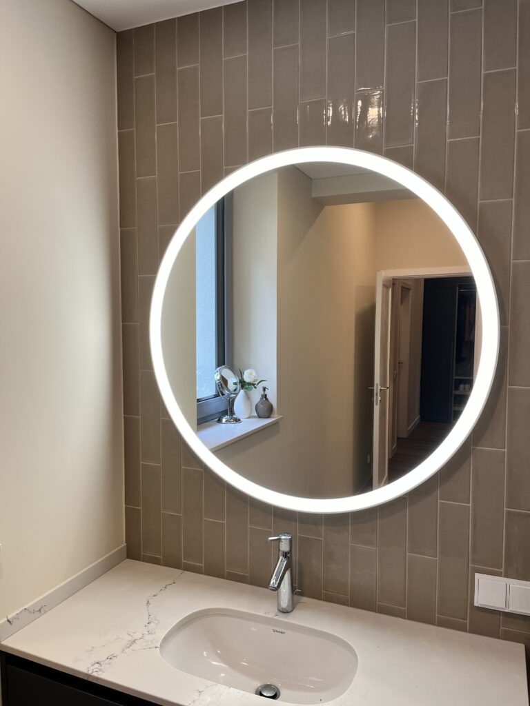 Apvalus veidrodis su smėlio spalvos rėmu ir LED apšvietimu palei kraštą — Vilnius