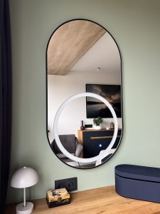 Piliulės formos veidrodis su LED apšvietimu ir juodu rėmeliu